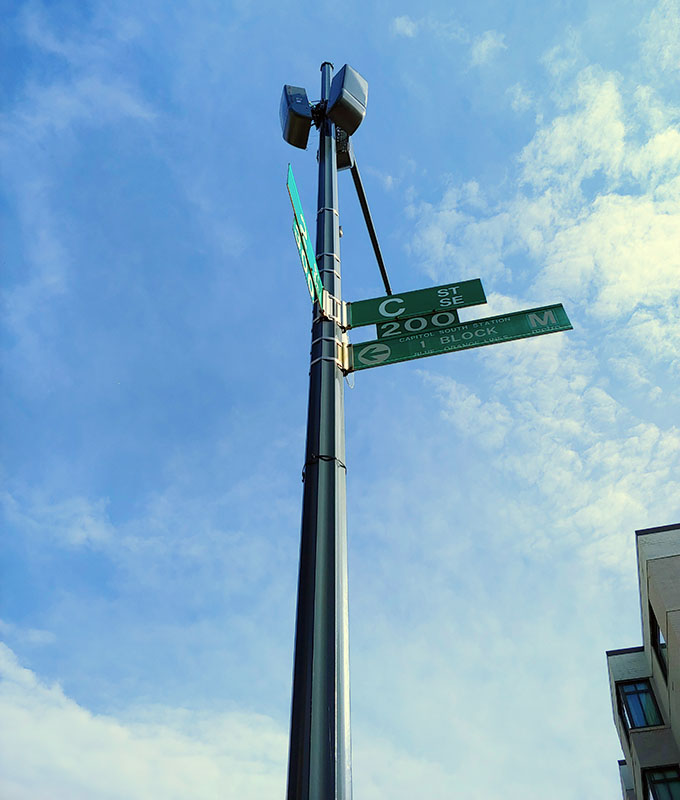 Photo of three, gray, 5G small cell units on top of the street sign pole at C Street & 2nd Street in Washington, DC