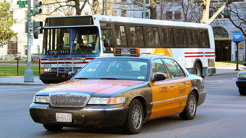 A taxicab and a Metrobus cross the intersection of 15th and Eye Streets NW in Washington DC. Photo by Ben Schumin on January 18, 2006.
