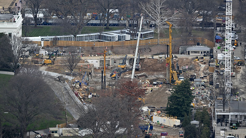 Construction of the White House State Ballroom on December 17, 2025. The East Wing of the White House has been completely demolished and work at ground level is ongoing. To the left of the construction site the edge of the White House is visible and behind the construction site is an enclosed walkway. 1600 Pennsylvania Avenue NW, Washington, D.C. 20500.