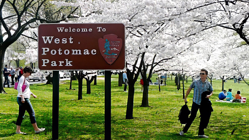 Visitors gathered on the banks of the Potomac for picnics and admiring the cherry blossoms. This "welcome to" sign greets you at the tip of 23rd St NW. Washington, DC.